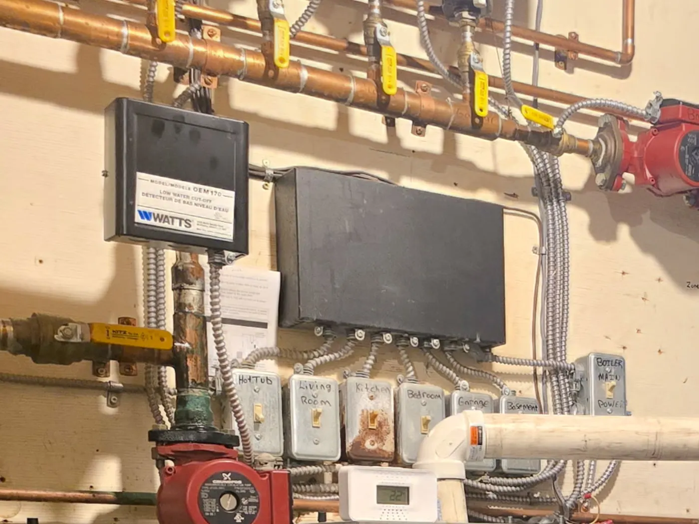 Technician adjusting a valve on a wall-mounted condensing boiler