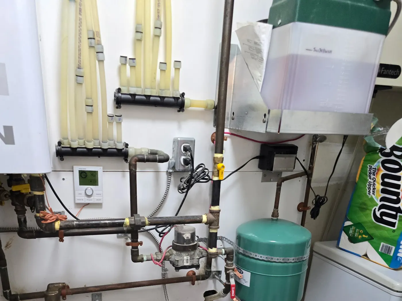 Hydronic manifold with zone loops and expansion tank installed by Rhino Plumbing