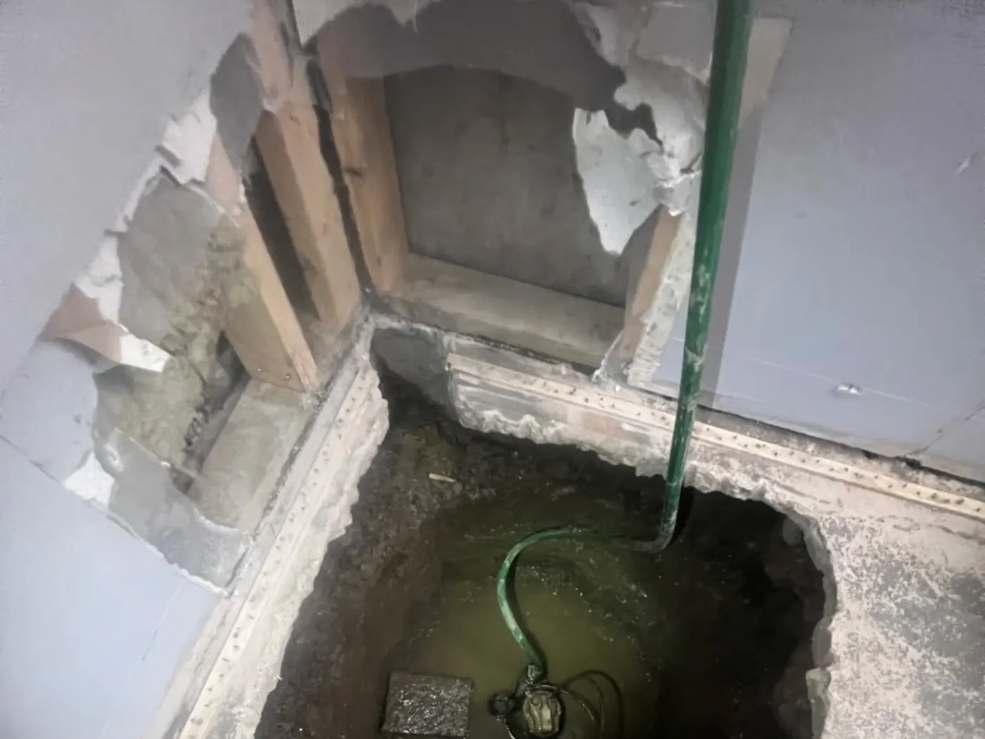 Sump pump set into a basement pit with the discharge line run